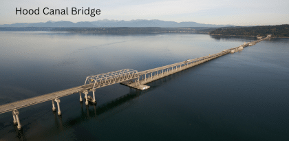 floating bridge across large body of water with mountains in the background